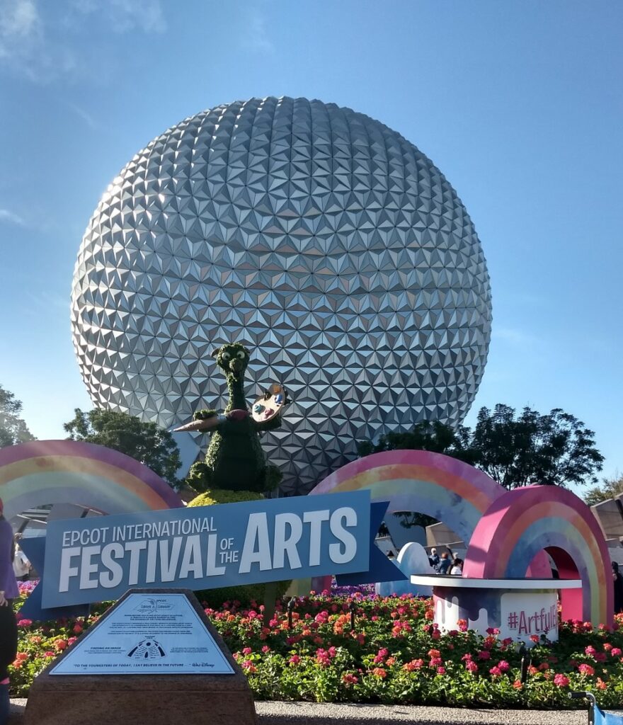 festival of the arts sign at epcot with figmet topiary